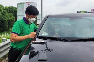 Nhân viên VETC đang dán thẻ thu phí tự động ETC cho khách trên cao tốc Nội Bài - Lào Cai.