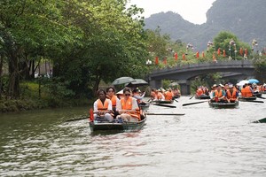 Các đại biểu tham quan quần thể danh thắng Tràng An bằng thuyền.