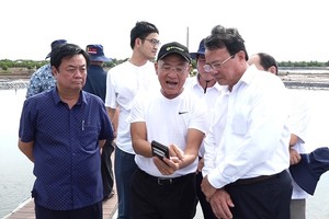 Bộ trưởng Bộ NN&PTNT Lê Minh Hoan (bìa trái) và Chủ tịch UBND tỉnh Trà Vinh Lê Văn Hẳn (bìa phải) tham quan mô hình nuôi tôm công nghệ cao hiệu quả của Tập đoàn Mỹ Lan - Ảnh Văn Vũ