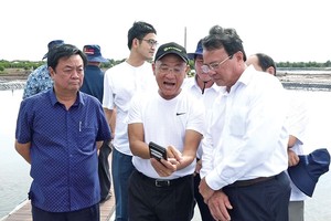 Bộ trưởng Bộ Nông nghiệp và Phát triển nông thôn Lê Minh Hoan (bìa trái) và Chủ tịch UBND tỉnh Trà Vinh Lê Văn Hẳn (bìa phải) tham quan mô hình nuôi tôm công nghệ cao hiệu quả của Tập đoàn Mỹ Lan tại tỉnh Trà Vinh. Ảnh: Văn Vũ