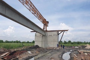 Nhà thầu thực hiện gác phiến dầm đầu tiên thuộc Gói thầu 12 của Dự án Đường ven sông đến Đông Triều - giai đoạn I Ảnh: Thu Lê