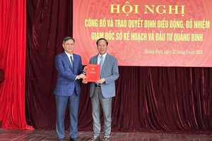 Chủ tịch UBND tỉnh Quảng Bình Trần Thắng (bên trái) trao quyết định và tặng hoa chúc mừng Giám đốc Sở Kế hoạch và Đầu tư Quảng Bình Nguyễn Xuân Đạt.
