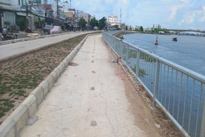 Vết nứt bê tông lót vỉa hè phía sau kè.