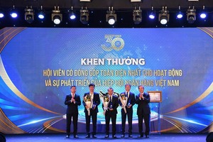 Ông Nguyễn Văn Bình - Nguyên Thống đốc NHNN (ngoài cùng bên phải) và ông Phạm Đức Ấn - Chủ tịch Hội đồng HHNHVN (ngoài cùng bên trái) trao giải “Hội viên đóng góp toàn diện nhất trong hoạt động và sự phát triển của HHNHVN”. Ông Đỗ Việt Hùng - Phó Bí thư Thường trực Đảng ủy, Thành viên HĐQT phụ trách hoạt động HĐQT đại diện Vietcombank nhận giải (đứng giữa)