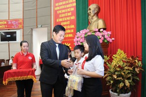 Ông Lâm Bình Vũ trao học bổng và quà cho các em học sinh