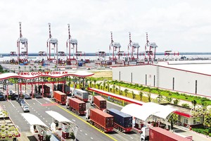 Xuất nhập khẩu là động lực chính cho phát triển ngành logistics. Trong ảnh: Xe container làm thủ tục thông quan tại Cảng quốc tế Long An 
