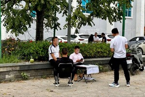 Các đội nhóm ngang nhiên rao bán chênh ngay trước nơi tổ chức phiên đấu giá đất. Ảnh: Thanh Vũ