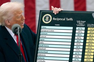 Tổng thống Trump giơ tấm bảng mức thuế các nước đang áp với Mỹ và thuế đối ứng. Ảnh: REUTERS