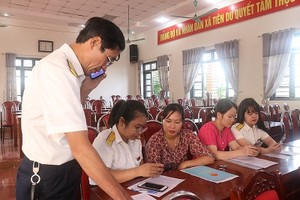 Công chức ngành thuế hỗ trợ pháp lý cho hộ kinh doanh, doanh nghiệp nhỏ và vừa. Ảnh: V. Học