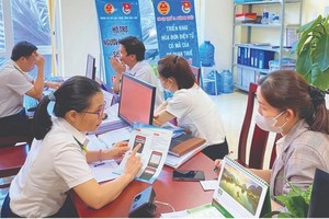 Công chức thuế hướng dẫn người dân, doanh nghiệp. 