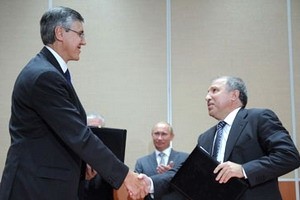 Giám đốc Rosneft, Eduard Khadainatov (phải) bắt tay Chủ tịch ExxonMobil, Neil Duffin trước sự chứng kiến của Thủ tướng Nga Putin. (Nguồn: AP)