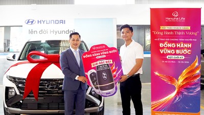 Khách hàng Nguyễn Quốc Đạt (bên phải) nhận giải Đặc biệt ô tô Hyundai Tucson từ chương trình khuyến mại “Đồng Hành Vững Bước” của Hanwha Life Việt Nam