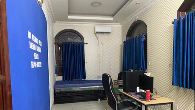 Một căn phòng nơi các đối tượng nước ngoài trú ngụ đã 'đầy đủ" phông bạt mô phỏng cơ quan chức năng nước ngoài cùng máy móc nghi vấn phục vụ lừa đảo online