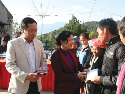 Bà Giàng Páo Mỷ (Chủ tịch HĐND, Trưởng đoàn Đại biểu Quốc hội tỉnh Lai Châu) và ông Lê Trọng Minh, Phó Tổng Biên tập Báo Đầu tư trao quà Tết cho các hộ nghèo ở xã Tả Lèng 