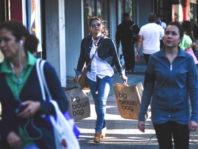 Người dân Mỹ đi dạo và mua sắm trên đường phố. Ảnh: Bloomberg