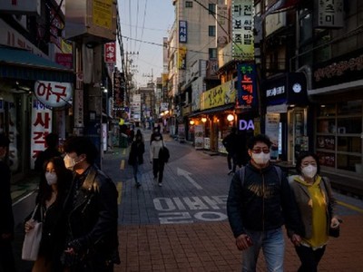 Người dân đi bộ trên đường phố Seoul hôm 24/3. Ảnh: AFP