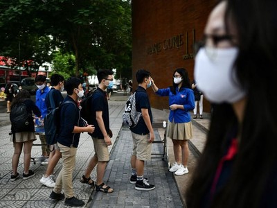 Kiểm tra thân nhiệt đối với học sinh tại các trường học ở Hà Nội. Ảnh: AFP