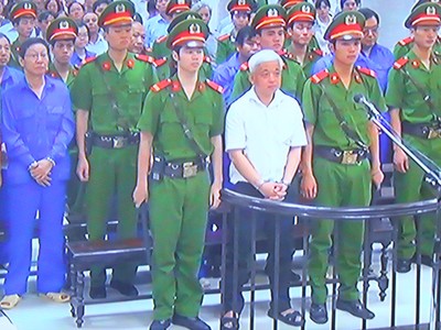 Bị cáo Nguyễn Đức Kiên (áo trắng) cùng các bị cáo khác tại tòa trong phiên sơ thẩm (Ảnh chụp qua màn hình)