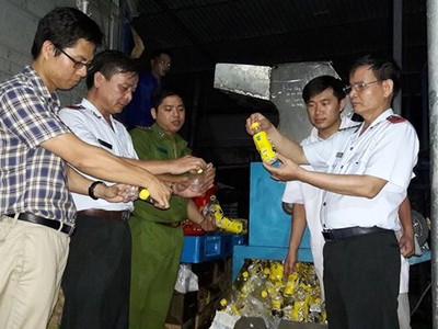 Đoàn thanh tra cùng đại diện Công ty URC Hà Nội giám sát việc tiêu hủy hàng không đạt chất lượng. (Ảnh: BYT cung cấp)