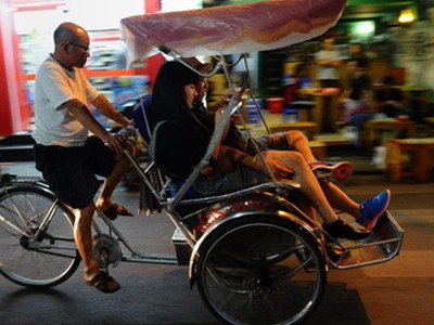 Du khách quốc tế ngồi xích lô tham quan phố cổ Hà Nội. (Ảnh: AFP)