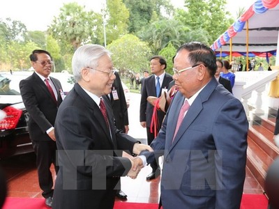 Tổng Bí thư, Chủ tịch nước Lào Bounhang Volachith đón Tổng Bí thư Nguyễn Phú Trọng. (Ảnh: Trí Dũng/TTXVN)