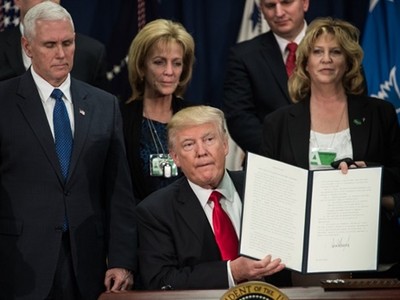 Tổng thống Donald Trump ký sắc lệnh bắt đầu kế hoạch xây tường biên giới với Mexico tại Bộ An ninh Nội địa ngày 25/1. Ảnh: AFP.