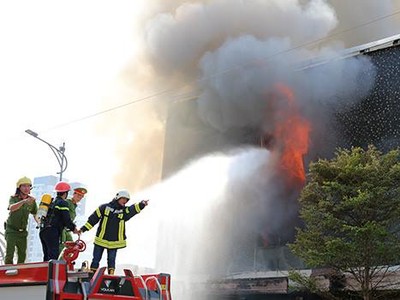 Lính cứu hoả tiếp cận dập lửa từ mặt tiền quán bar. Ảnh: Ngọc Trường.