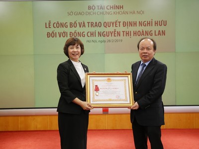 Thứ trưởng Bộ Tài chính Huỳnh Quang Hải  trao Huân chương lao động hạng nhì cho bà Nguyễn Thị Hoàng Lan. 