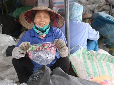 Bà Nguyễn Thị Hồng Thắm cầm một vỏ túi kẹo có xuất xứ từ Mỹ. Ảnh: Guardian.