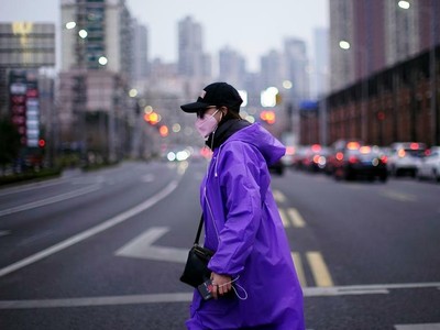 Một phụ nữ đi lại trên đường phố Thượng Hải (Trung Quốc) cuối tháng 2. Ảnh: Reuters.