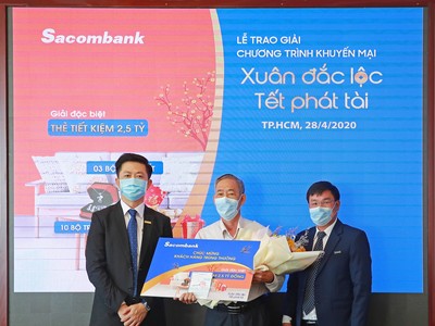  Ông Nguyễn Minh Tâm – Phó tổng giám đốc Sacombank (bên trái) trao sổ tiết kiệm trị giá 2,5 tỷ đồng cho khách hàng Hà Văn Thường (giữa), người may mắn trúng giải đặc biệt chương trình khuyến mãi “Xuân đắc lộc – Tết phát tài”.