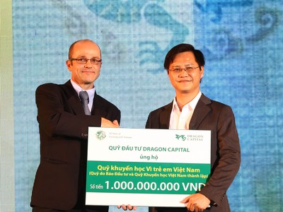 Ông Nguyễn Hồng (phải), Phó Tổng biên tập Báo Đầu Tư đón nhận tiền tượng trưng cho quỹ học bổng của báo từ đại diện của Dragon Capital - ảnh: Lê Toàn