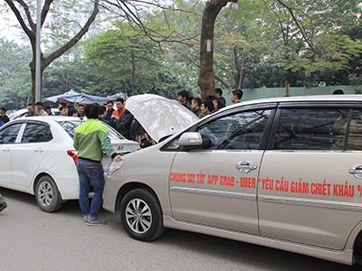 Tài xế dán khẩu hiệu với thông điệp yêu cầu Uber, Grab giảm chiết khấu lên thân xe. Ảnh: Anh Tú