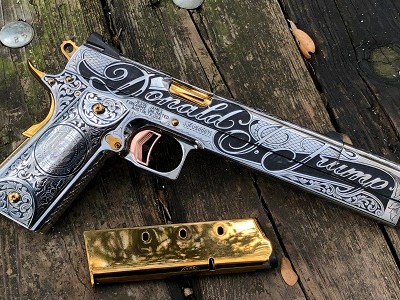 Một mặt của súng có dòng chữ "Donald Trump" và huy hiệu Tổng thống Mỹ. Ảnh: Maxim.