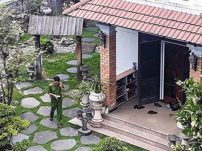 Công an trong khuôn viên nhà ông Minh. 