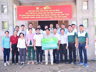 Gia đình ông Huỳnh Văn Được cùng đại diện Vietcombank và lãnh đạo địa phương chụp ảnh lưu niệm bên ngôi nhà mới.