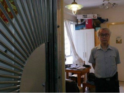 Ông chủ nhà Ng Goon-lau, 66 tuổi, đứng trong căn hộ của mình, nơi từng xảy ra hai vụ tự tử, một người đàn ông tự tử bằng than, một nữ cảnh sát treo cổ. Ảnh: Reuters.