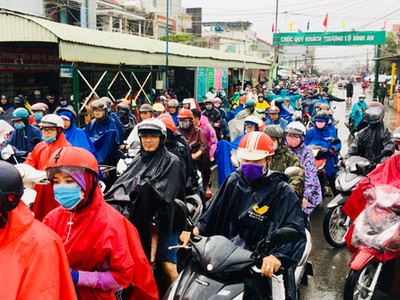 Dòng người xếp hàng dài trong mưa chờ qua phà Cát Lái ở phía bờ Nhơn Trạch, tỉnh Đồng Nai. Ảnh: Hữu Nguyên.