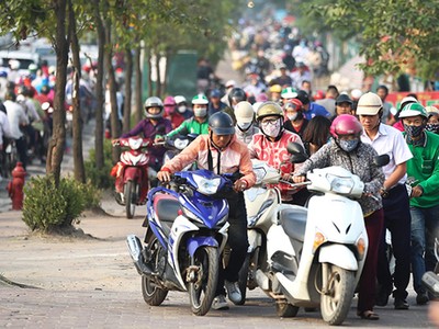 Bị cấm đường, người dân leo lên vỉa hè đường Lê Văn Lươngđi ngược chiều. Ảnh:Ngọc Thành.