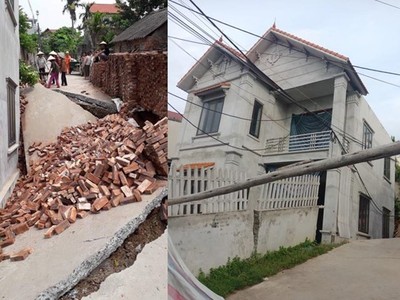 Hình ảnh con đường bị sụt sâu xuống 3-4m cùng ngôi nhà bị lún (Ảnh: Nguyễn Kim Tuấn/Vietnam+).