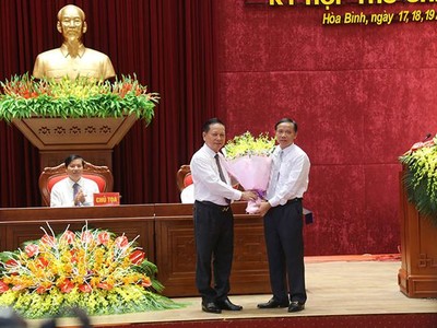 Ông Bùi Văn Tỉnh, Ủy viên BCH Trung ương Đảng, Bí thư Tỉnh ủy Hòa Bình tặng hoa chúc mừng ông Bùi Văn Khánh được bầu giữ chức Chủ tịch UBND tỉnh. 