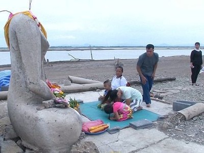 Du khách và người dân tới hành lễ trước một pho tượng Phật cao chừng 4m của ngôi đền cũ.