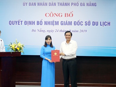 Ông Trần Văn Miên trao quyết định và tặng hoa cho bà Hạnh. 