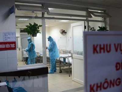 Các nhân viên y tế mặc áo quần, khẩu trang bảo hộ khi vào điều trị cho bệnh nhân bị cách ly. (Ảnh: Văn Dũng/TTXVN).