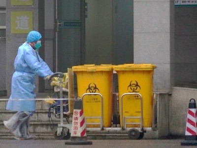 Công nhân thu gom rác thải y tế tại một trung tâm điều trị bệnh nhân nhiễm Covid-19 ở Vũ Hán hôm 22/1. Ảnh: 
AP.