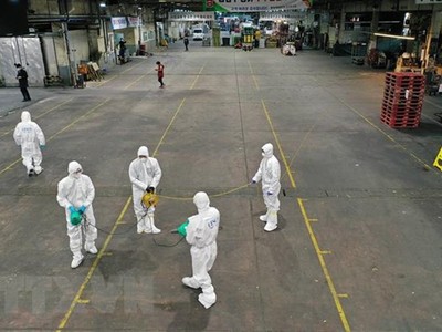 Phun thuốc khử trùng tại một chợ rau củ ở thành phố Daegu, Hàn Quốc nhằm ngăn chặn sự lây lan của dịch COVID-19, ngày 20/2/2020. (Ảnh: AFP/TTXVN).