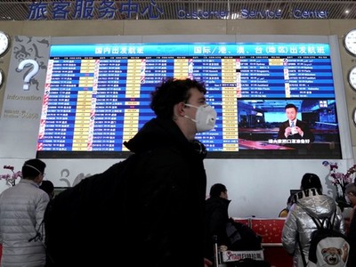 Hành khách đeo khẩu trang tại sân bay Bắc Kinh. (Ảnh: Reuters).