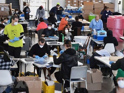 Nhân viên Hãng sản xuất công nghiệp thiết bị phòng hộ PPE chế tạo thiết bị phòng dịch COVID-19 để cung cấp cho các bệnh viện và cơ sở y tế, tại một khu xưởng của hải quân ở Brooklyn, New York (Mỹ) ngày 26/3/2020. (Nguồn: AFP/TTXVN).