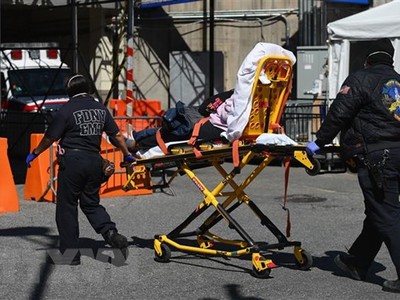 Nhân viên y tế chuyển bệnh nhân nhiễm COVID-19 tới trung tâm y tế Brooklyn, New York, Mỹ. (Ảnh: AFP/TTXVN).