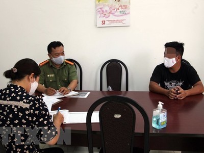 Cơ quan chức năng làm việc với Nguyễn Lập T. (áo đen). (Ảnh: TTXVN phát).